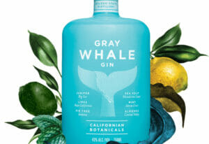 a bottle of Gray Whale Gun with limes and lemons